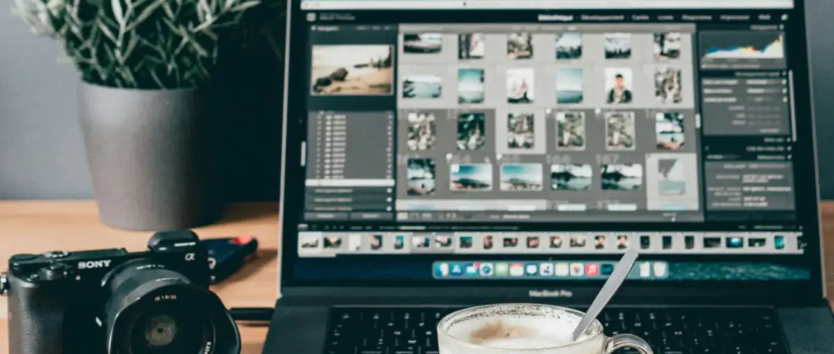 laptop beside white ceramic mug on brown wooden table