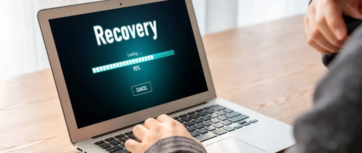 An image of a person using software to recover photos on their laptop.