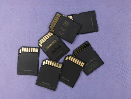 An image of a USB flash drive and memory cards on a blank background.